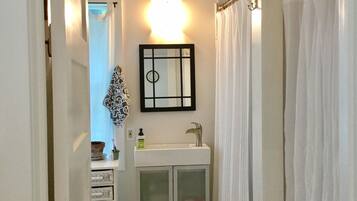A bathroom with a white sink, a mirror, and a shower curtain.