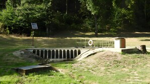 A water management structure with a solar panel, a metal railing, and a small wooden building. - Le Chalet de Pierre Sèche – up to 8 guests (Chaumard)