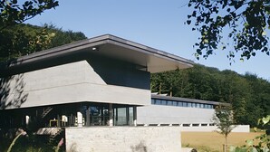 A modern building with a sloped roof, large windows, and a brick base. - Le Chalet de Pierre Sèche – up to 8 guests (Chaumard)