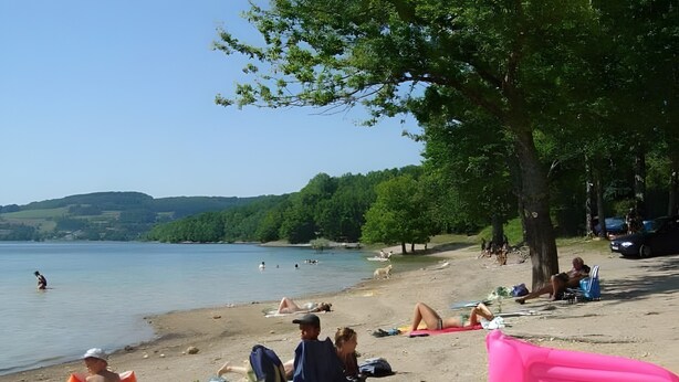 A beach with people sunbathing, a lake, and hills in the background. - Le Chalet de Pierre Sèche – up to 8 guests (Chaumard)