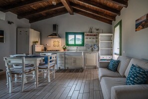 Eine gemütliche Küche mit Esstisch, Stühlen und einer Couch in ländlichem Stil.