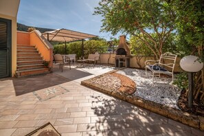A patio with outdoor furniture, a barbecue grill, and a stone pathway. - Atzori Home - Sant'Anna Arresi (Sant`Anna Arresi)