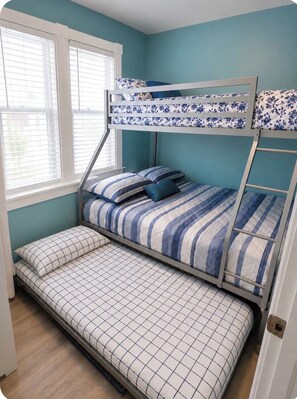 Een stapelbed met een bed beneden en een bed boven, beide met bloemenbeddengoed.