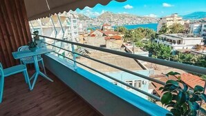 Ein Balkon mit Blick auf eine Stadtlandschaft und ein Gewässer.