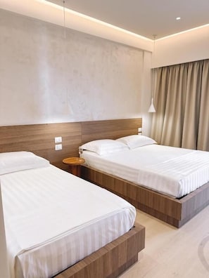 A hotel room with two beds, a wooden headboard, a bedside table, and a large window with curtains. - SIÁMAR Studio Rooms (Saranda)