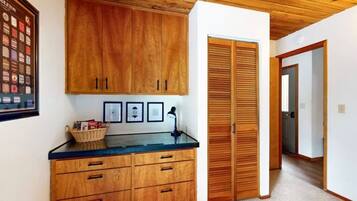 A wooden cabinet with drawers, a framed picture collection, and a basket on a counter.