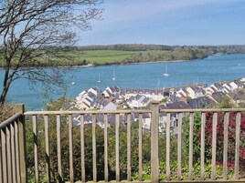 A coastal residential area with houses, a wooden fence, and a view of the sea.