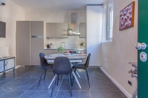 A modern kitchen with a dining table, chairs, and a window.