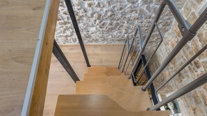 A wooden staircase with metal railings leading to a stone wall. - Casa di Pietra Apartment (Split)