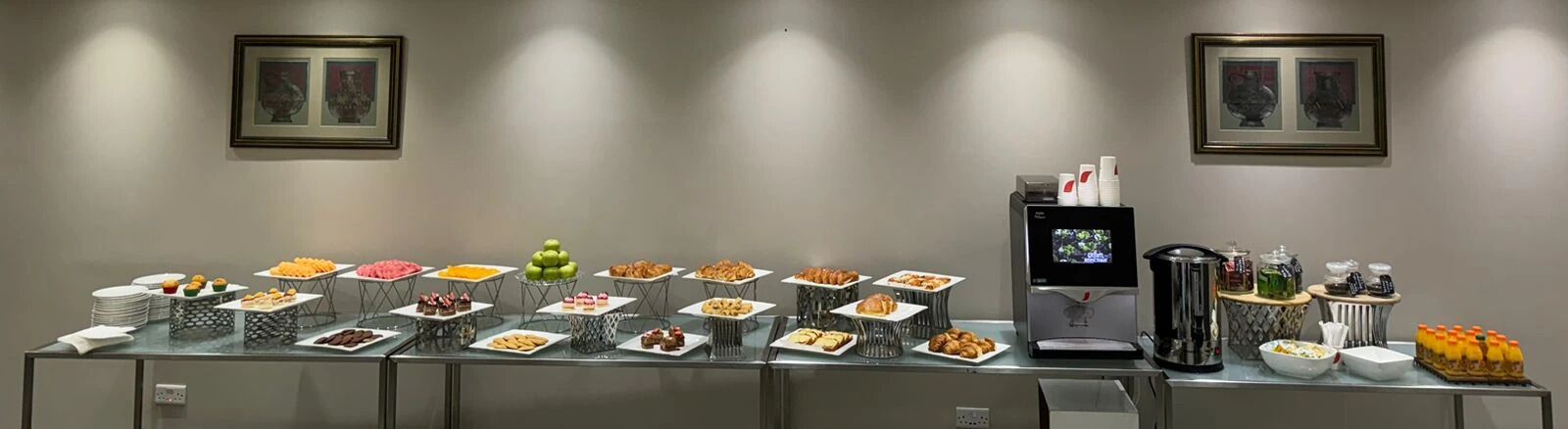 A buffet setup with various food items and a coffee machine.