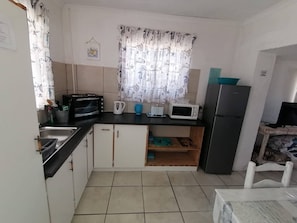 A compact kitchen with a toaster, microwave, and refrigerator.