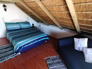 A room with a bed, a small table, and a bench.