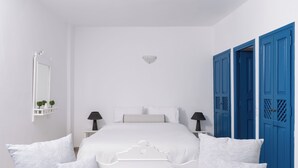 Ein Schlafzimmer mit einem Bett, Nachttischen, einem Spiegel und blauen Türen.