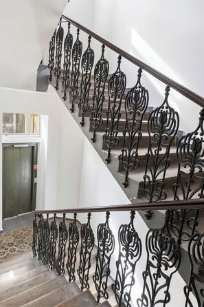 A staircase with ornate black metal railings and a modern interior design. - Prime Chief Suite Apartworld (Praha)