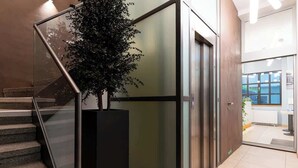 Ein modernes Interieur mit Treppe, einem Blumentopf und einer Glastür zu einem Raum mit Aussicht.