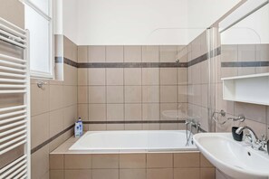 Ein Badezimmer mit Badewanne, Waschbecken und Spiegel.