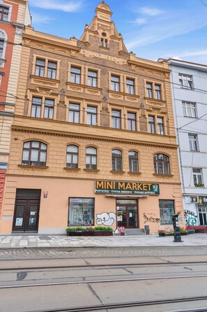 Ein Gebäude mit einem Schild, auf dem 'MINI MARKET' steht, und einer Schaufensterfront mit einem großen Fenster.