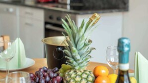 A kitchen with a fruit basket, wine glasses, and a bottle on the counter. - Old Town Suite Apartworld (Hlavní město Praha)