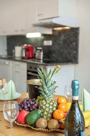 A kitchen with a fruit basket, wine glasses, and a bottle on the counter. - Old Town Suite Apartworld (Hlavní město Praha)