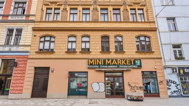 A building with a storefront labeled 'MINI MARKET' featuring a traditional architectural style with multiple windows and a central entrance. - Old Town Suite Apartworld (Hlavní město Praha)