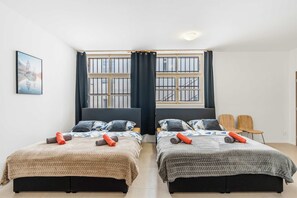 A room with two beds, a window with bars, a painting on the wall, and two chairs. - Secret Courtyard Residence Apartworld (Praha)