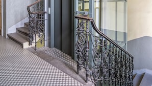 A staircase with ornate metal railings and a checkered floor pattern. - Historic Prague Residence Apartworld (Praha)