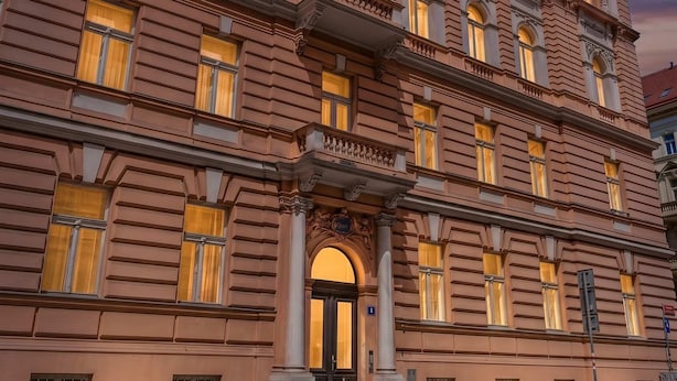 A multi-story building with a classical architectural style, featuring a central entrance with a large archway, multiple windows, and a flat roof. - Historic Prague Residence Apartworld (Praha)