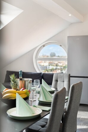 Ein moderner Essbereich mit einem Tisch für zwei Personen, einer Ananas, Bananen und einer Champagnerflasche.