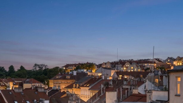 Un jacuzzi en la azotea con vistas a la ciudad, una vela y una copa de champán.