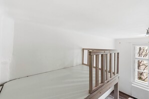 Ein Zimmer mit Etagenbett, weißer Wand, Fenster mit Blick und Heizkörper.