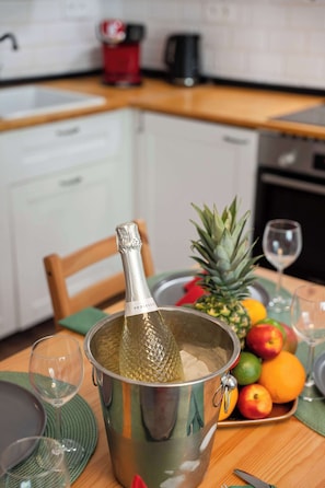 A kitchen with a stainless steel pot, a pineapple, and a fruit bowl on the table. - City Comfort Terrace Prague (Praha)