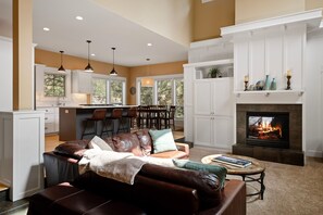 A spacious living room with a fireplace, a dining area, and a kitchen. - River Wild at Mt Bachelor Village - Hot Tub + Pool (Bend)