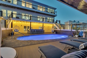 Ein modernes Haus mit Pool, Außenbar und Lounge-Bereich.