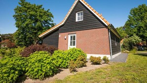 A single-story house with a gabled roof, a brick exterior, and a small front porch.