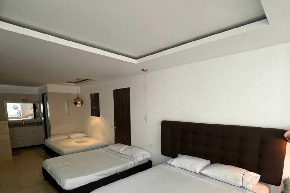 Habitación triple Deluxe, vista a la alberca | Escritorio, espacio para trabajar con laptop y wifi gratis