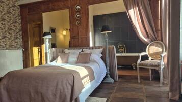 Ein Schlafzimmer mit einem großen Bett, einem Sessel und einem Schreibtisch.