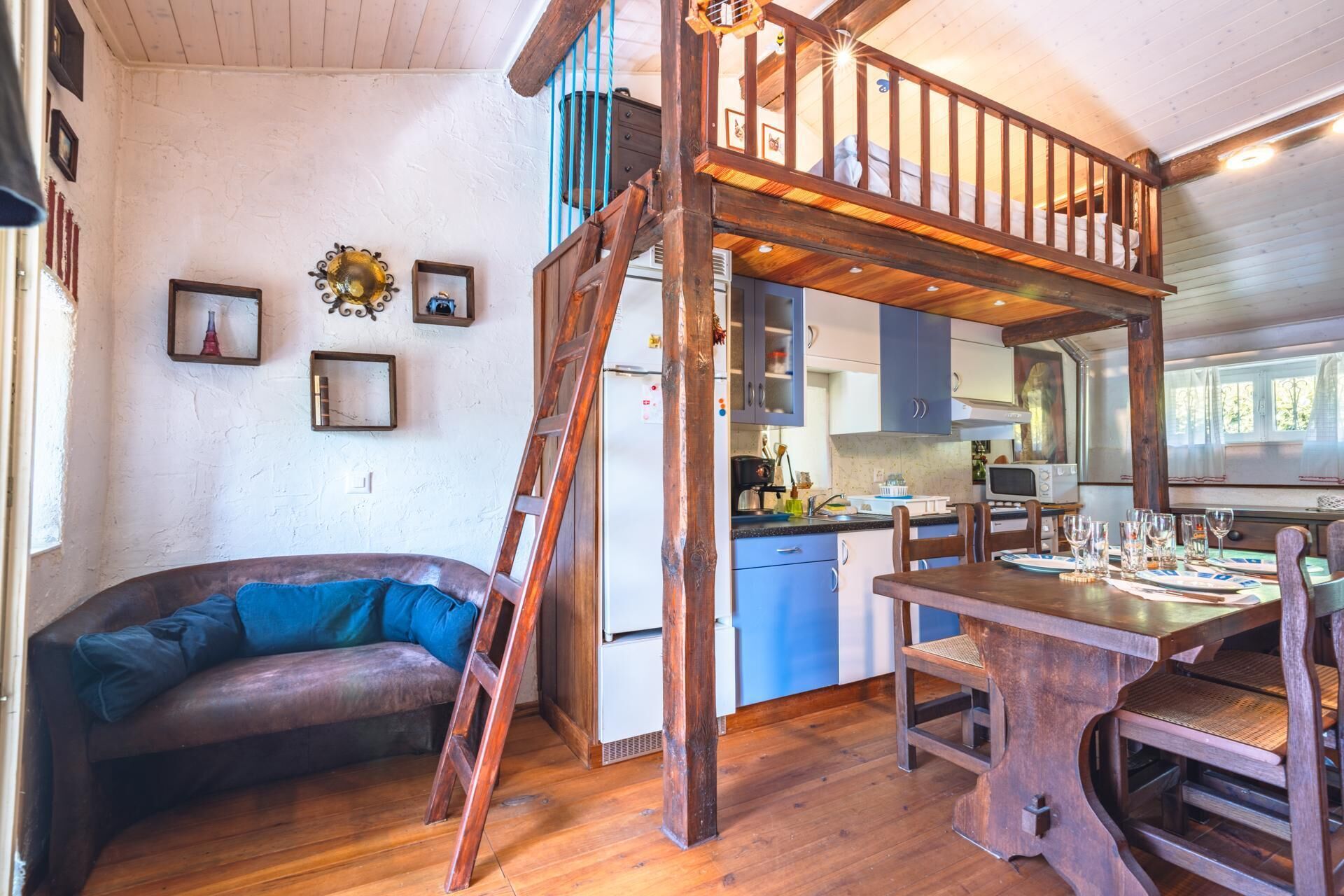 Ein rustikales Blockhaus mit Schlafzimmer im Zwischengeschoss, Essbereich und Küche.