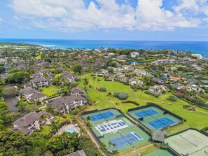 An aerial view of a residential area with houses, green spaces, and tennis courts. - Aston at Poipu Kai | Walk to Beach | 2 Pools | Private Lanai | Tennis (Koloa)