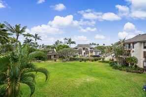 Een woonwijk met huizen, een verzorgd gazon en palmbomen.