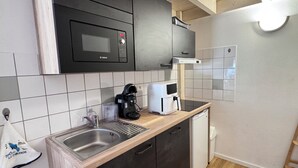 Una cocina equipada con microondas Bosch, cafetera y lavavajillas.