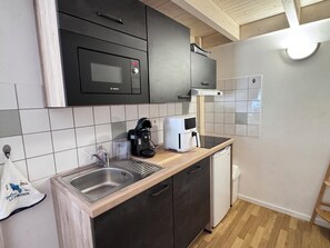 Een keuken met een Bosch magnetron, koffiezetapparaat en vaatwasser.