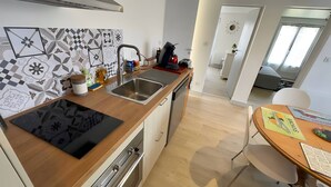 Une cuisine moderne dotée d’un plan de travail en bois, d’un évier en acier inoxydable et d’un four encastré.
