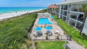 Een hotel met een zwembad, terras en uitzicht op het strand.