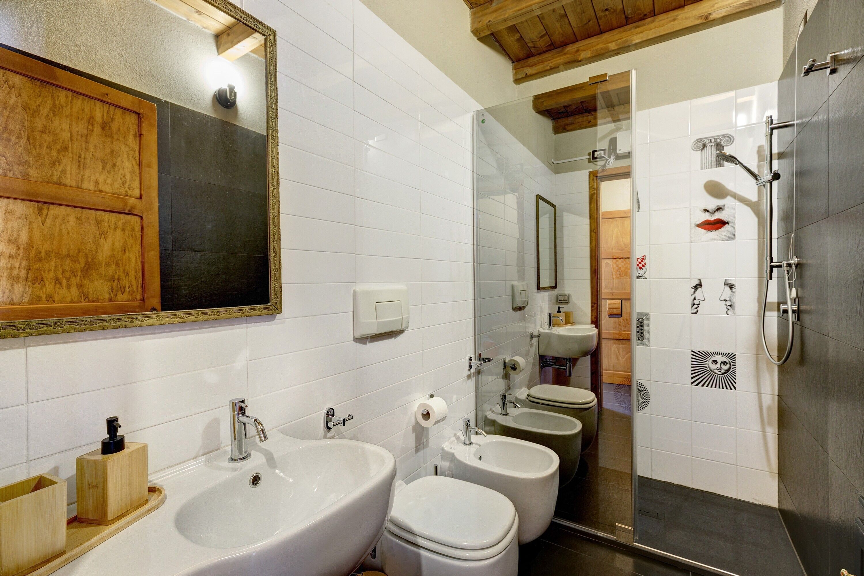 Ein Badezimmer mit einem großen Spiegel, einem Waschbecken, einem Bidet und einer Dusche.