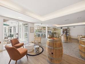 A spacious room with a bar area, wooden barrels, and comfortable seating. - The Swallow - Apt for 4 - Shared Pool (Biscarrosse)
