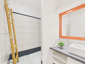 A bathroom with white tiles, a bamboo ladder, a mirror with an orange frame, and a small potted plant. - House for 4, 100m from sea, terrace & BBQ (Les Anses-d´Arlet)
