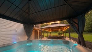 A hot tub with a wooden deck and string lights, surrounded by a covered patio area. - Ohiopyle Weddings, Family Getaway, Bridal Party (Ohiopyle)