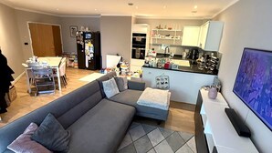 Ein modernes Wohnzimmer mit Ecksofa, Essbereich und Küche.