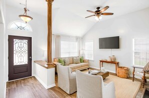 A living room with a sofa, chairs, a TV, and a ceiling fan. - Step-Free Family Home with BBQ in Montgomery (Montgomery)
