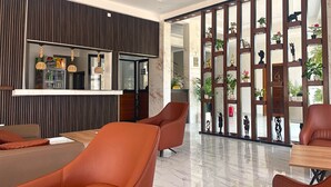 A modern hotel lobby with a seating area, a refreshment bar, and a decorative partition with plants. - Standard "All-Comfort" Room in Dakar: Excellent Value for the Money (Dakar)